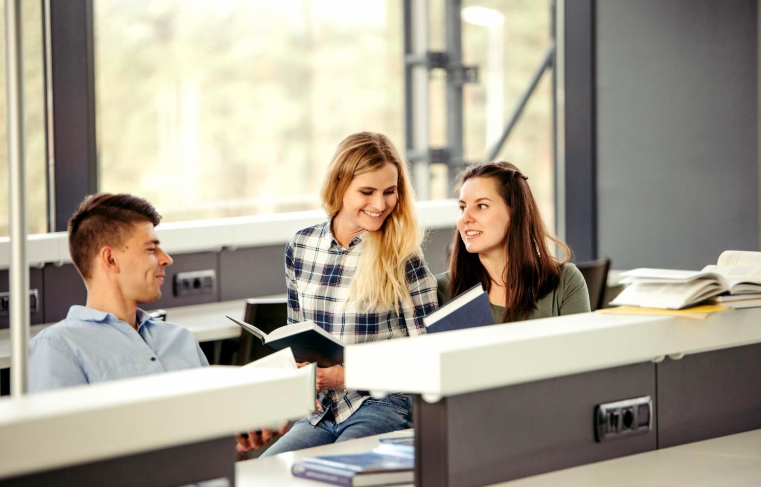 Estudiantes trabajando con análisis financieros y reportes presupuestarios en aula moderna